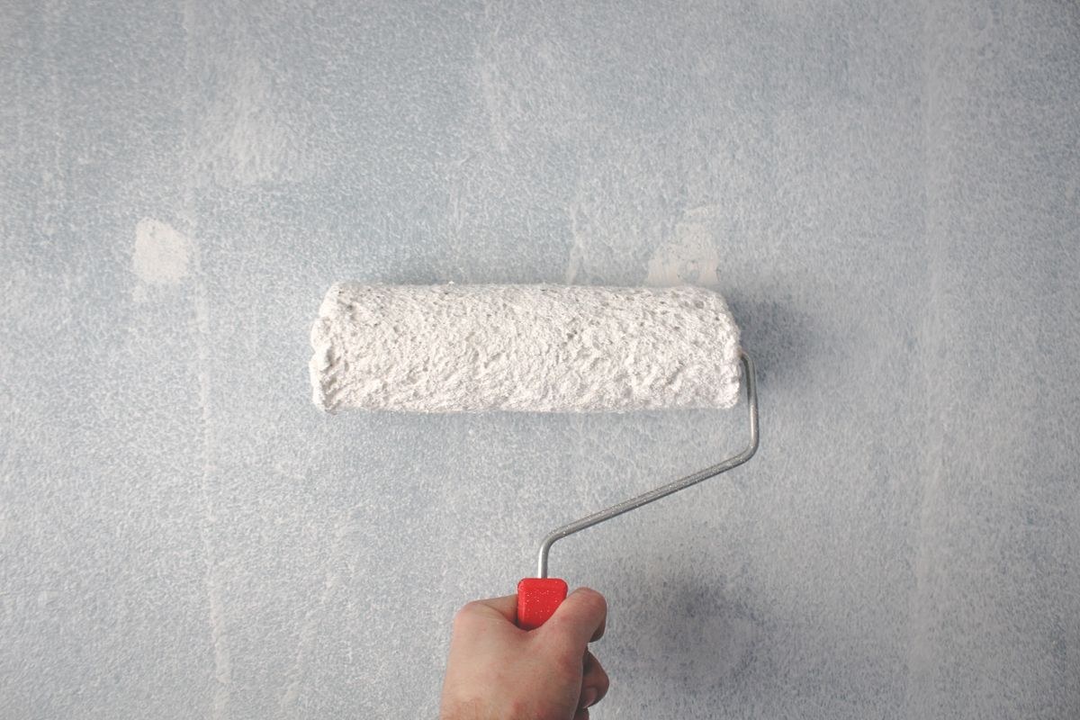Close-up of a paint roller applying colour to an interior wall